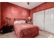 Bedroom with red walls and striped bedding at 6216 W Morrow Dr, Glendale, AZ 85308