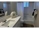 Bright bathroom features a modern white vanity with a large white sink and a shower-tub combo at 8144 E Kilarea Ave, Mesa, AZ 85209