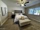 Comfortable bedroom with a tufted headboard bed, soft carpet, and ample natural light at 8144 E Kilarea Ave, Mesa, AZ 85209