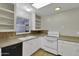 Bright kitchen with white cabinets, neutral countertops, and sleek black appliances under a window overlooking the yard at 914 N Cameron Ave, Casa Grande, AZ 85122