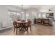 Bright dining area with wood table and chairs, open to Gathering room at 9915 N 57Th Ln, Glendale, AZ 85302