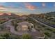 Aerial view of home with circular driveway and sunset mountain views at 10031 N Palisades Blvd, Fountain Hills, AZ 85268