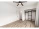 Bedroom with wood-look floors, ceiling fan, and closet with built-in shelving at 1018 S Butte Ave, Tempe, AZ 85281