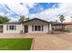 Charming single-story home featuring white siding, dark shutters, and a well-manicured front yard at 1018 S Butte Ave, Tempe, AZ 85281