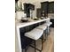 Modern kitchen island with a white countertop, black cabinetry, and seating for casual dining at 1018 S Butte Ave, Tempe, AZ 85281