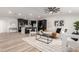 Stylish open-concept living room with sleek flooring, modern decor, and black kitchen in the background at 1018 S Butte Ave, Tempe, AZ 85281