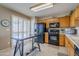 Modern kitchen with black appliances and wood cabinets at 10356 W Ross Ave, Peoria, AZ 85382