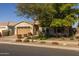 Tan two-story house with a three-car garage and nicely landscaped front yard at 10556 E Relativity Ave, Mesa, AZ 85212