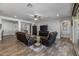 Living room with dark brown leather couches and wood-look tile floors at 10556 E Relativity Ave, Mesa, AZ 85212