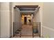 Inviting entryway with a metal gate and pathway leading to a wood front door at 11060 E Mark Ln, Scottsdale, AZ 85262