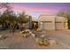 Tan stucco home with a two-car garage and drought-tolerant landscaping, creating a low-maintenance exterior at 11060 E Mark Ln, Scottsdale, AZ 85262