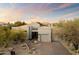 Desert landscape surrounds this single-story home with a neutral facade and two-car garage at 11060 E Mark Ln, Scottsdale, AZ 85262