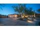 Night view of a two-story home with a two-car garage and well-lit landscaping at 12824 E Jenan Dr, Scottsdale, AZ 85259