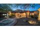 Inviting front yard with fountain and landscape lighting at dusk at 12824 E Jenan Dr, Scottsdale, AZ 85259