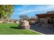 Outdoor kitchen and dining area with pizza oven, adjacent to a grassy lawn at 12824 E Jenan Dr, Scottsdale, AZ 85259