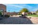 Stone patio with fireplace and grassy backyard at 12824 E Jenan Dr, Scottsdale, AZ 85259