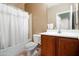 Clean bathroom with tub, toilet, and wooden vanity at 15296 W Coolidge St, Goodyear, AZ 85395