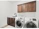 Laundry room with modern washer and dryer, marble countertop, and wood cabinets at 16328 E Ridgeline Dr, Fountain Hills, AZ 85268