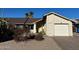 Front exterior view of a single story home with a two car garage and desert landscaping at 1638 E Sandra Ter, Phoenix, AZ 85022