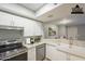 Modern kitchen with white cabinets, stainless steel appliances, and farmhouse sink at 1645 W Baseline Rd # 2075, Mesa, AZ 85202