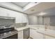 Modern kitchen with white cabinets, stainless steel appliances, and farmhouse sink at 1645 W Baseline Rd # 2075, Mesa, AZ 85202