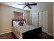 Cozy bedroom with a floral-patterned bed, ceiling fan, and double-door closet at 16636 S 34Th Way, Phoenix, AZ 85048