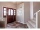 Entryway with tiled floors, a wooden door, and a carpeted staircase at 16636 S 34Th Way, Phoenix, AZ 85048