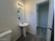 Bathroom with pedestal sink, toilet and access to hall at 1727 W Pollack St, Phoenix, AZ 85041