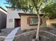 Tan two-story house with red door, tree, and walkway at 1727 W Pollack St, Phoenix, AZ 85041