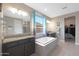 Spa-like bathroom with soaking tub, double vanity, and walk-in closet at 18404 W Long Lake Rd, Goodyear, AZ 85338