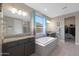 Bathroom with double vanity, soaking tub, and walk-in shower at 18404 W Long Lake Rd, Goodyear, AZ 85338