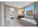 Bathroom with soaking tub, bedroom access and natural light at 18404 W Long Lake Rd, Goodyear, AZ 85338