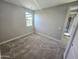 Neutral bedroom with plush carpeting, a view to the backyard pool through a window, and light gray walls at 18404 W Long Lake Rd, Goodyear, AZ 85338