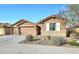 Tan two-story house with a three-car garage and landscaping at 18404 W Long Lake Rd, Goodyear, AZ 85338