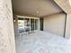 Covered patio with travertine tile, sliding glass doors, and an outdoor light fixture at 18404 W Long Lake Rd, Goodyear, AZ 85338