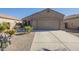 One-story house with a tan stucco exterior, two-car garage, and desert landscaping at 18509 N Toya St, Maricopa, AZ 85138