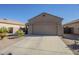 Tan stucco house with a two-car garage and well-maintained landscaping at 18509 N Toya St, Maricopa, AZ 85138