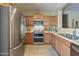 Modern kitchen with stainless steel appliances and light wood cabinets at 18509 N Toya St, Maricopa, AZ 85138