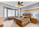 Bedroom with rustic wooden bed frame, window seat, and ceiling fan at 21295 N 262Nd Dr, Buckeye, AZ 85396