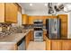 Modern kitchen with stainless steel appliances and wood cabinets at 21295 N 262Nd Dr, Buckeye, AZ 85396