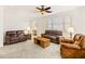 Bright living room with two brown leather sofas, a coffee table, and ceiling fan at 21295 N 262Nd Dr, Buckeye, AZ 85396