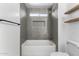 Clean bathroom with gray tile, a bathtub, and floating shelves at 2193 S Tucana Ln, Gilbert, AZ 85295