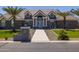 Elegant home exterior with a stone facade, palm trees, and a welcoming walkway at 21987 E Stacey Rd, Queen Creek, AZ 85142