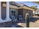 Charming rocking chairs on a brick patio with a large cactus, near the home's entrance at 21987 E Stacey Rd, Queen Creek, AZ 85142