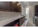 Laundry room with dark cabinets, quartz countertop, and patterned tile at 21987 E Stacey Rd, Queen Creek, AZ 85142