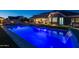 Inviting lighted pool with waterfall feature at night at 21987 E Stacey Rd, Queen Creek, AZ 85142