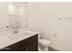 Modern bathroom featuring a dark wood vanity, white countertop, toilet, and framed mirror at 22541 W Pontiac Dr, Surprise, AZ 85387