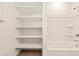 Bright white bathroom features built-in shelving beside a tub shower with modern fixtures at 22541 W Pontiac Dr, Surprise, AZ 85387