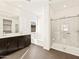 Modern bathroom with double vanity, soaking tub, and glass-enclosed shower at 22541 W Pontiac Dr, Surprise, AZ 85387