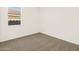 Cozy bedroom with plush carpeting, neutral paint, and a sunny window view at 22541 W Pontiac Dr, Surprise, AZ 85387